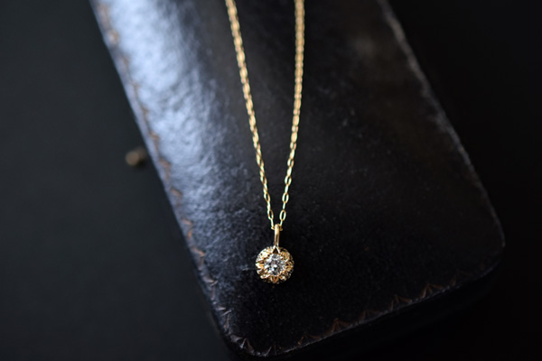 小さな表面に洋彫りの装飾模様が彫刻されたK18イエローゴールドのネックレストップです。＊静岡県浜松市ジュエリープシュケー